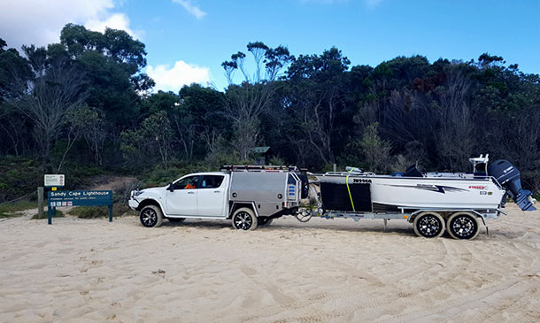 Twin cab Mazda 4wd towing a beautiful boat up the beach using a Belco tandem axle boat trailer.