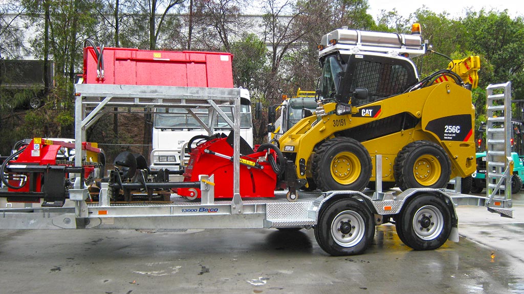 Belco plant trailer loaded with a yellow bobcat and accessories.