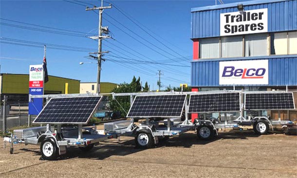 Four small flatbed trailers mounted with large solar panels.