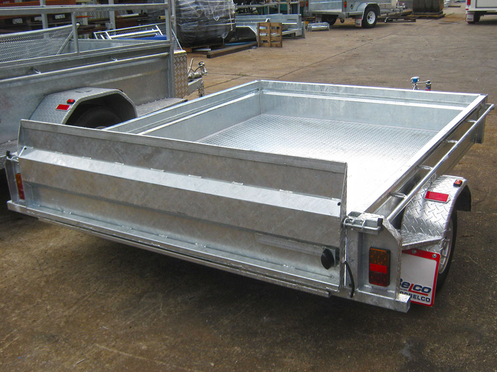 A Belco golf buggy trailer featuring a loading ramp and tie down rails.