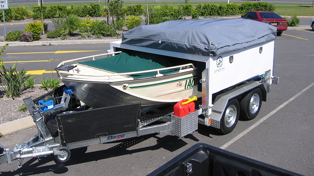 Belco land and sea camper trailer with aluminum boat and top-mounted, fold out family tent.